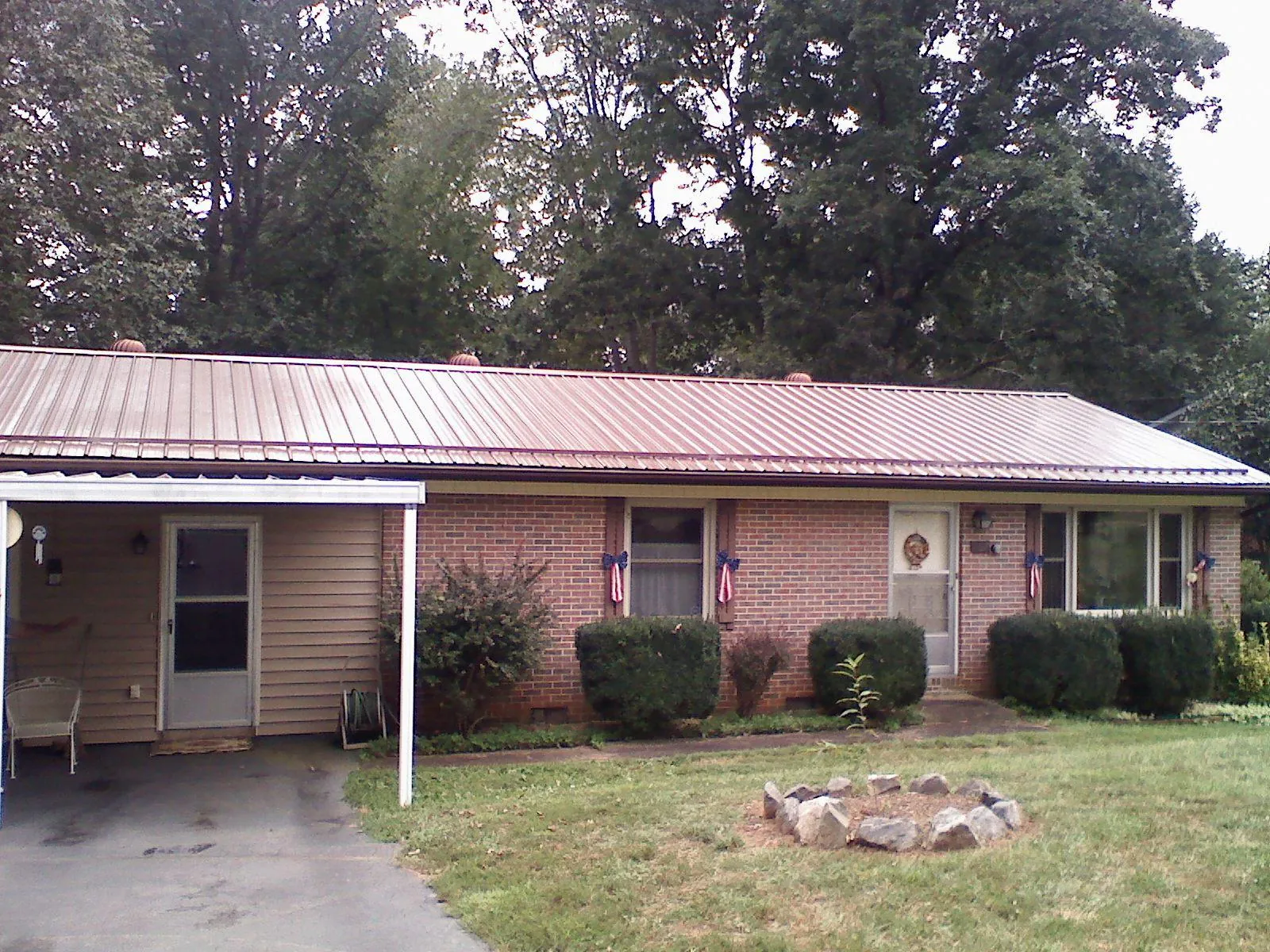 Bronze metal roof and carport on a brick ranch home — Roof Repair work by our crew in Bear